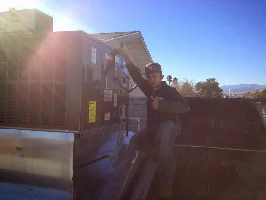 HVAC technician performing HVAC Inspection on a rooftop unit in Tooele